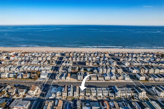 bird's eye view with a water view and a beach view