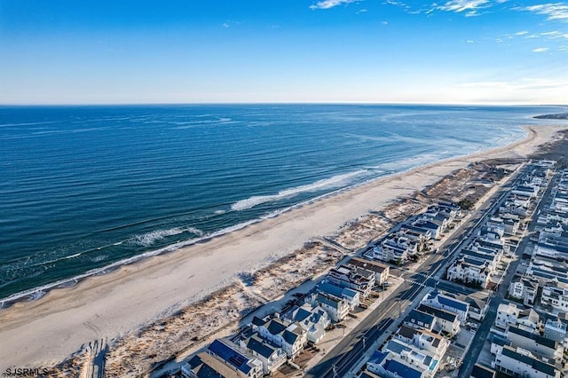 birds eye view of property with a water view and a beach view