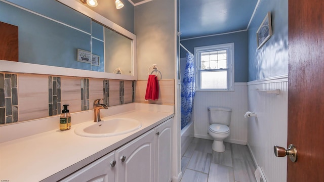 full bathroom with crown molding, hardwood / wood-style flooring, shower / tub combo, vanity, and toilet