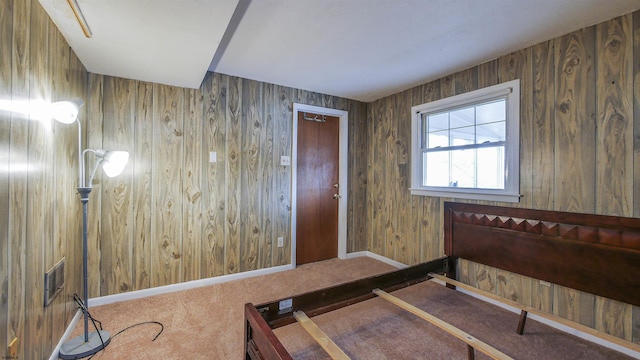 bedroom featuring carpet floors and wood walls