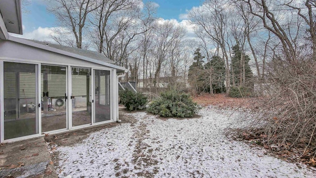 yard layered in snow with a sunroom