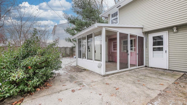 view of side of property featuring a patio and a sunroom