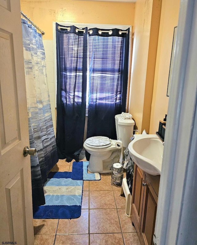 bathroom with tile patterned flooring, vanity, and toilet