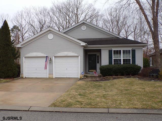 ranch-style house with a garage and a front lawn