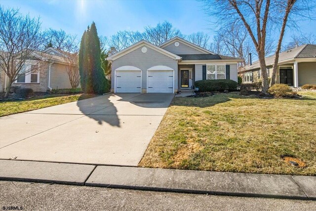 single story home featuring driveway, an attached garage, and a front yard