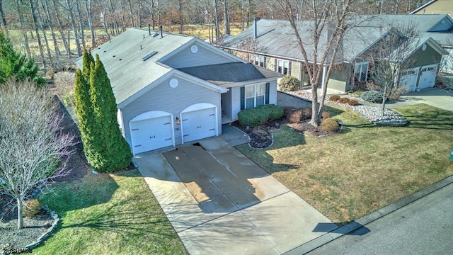 view of front facade featuring a shingled roof, a front yard, driveway, and an attached garage