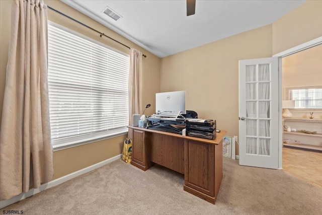 home office featuring light colored carpet, visible vents, lofted ceiling, and baseboards