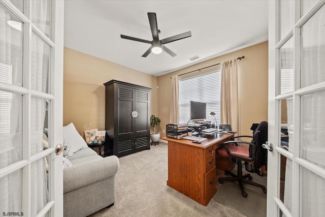 home office with light carpet, french doors, visible vents, and a ceiling fan