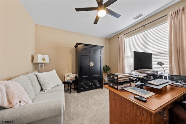 office area with light carpet, visible vents, and a ceiling fan