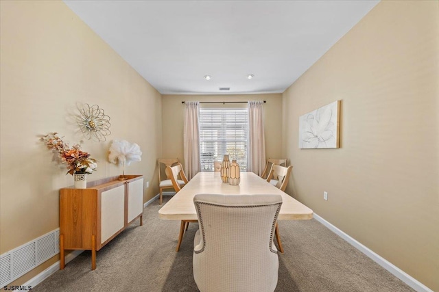 carpeted dining space with visible vents and baseboards