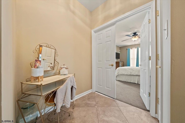 interior space with light tile patterned flooring, light carpet, and baseboards