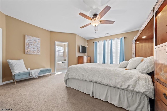 carpeted bedroom with visible vents, connected bathroom, baseboards, and ceiling fan