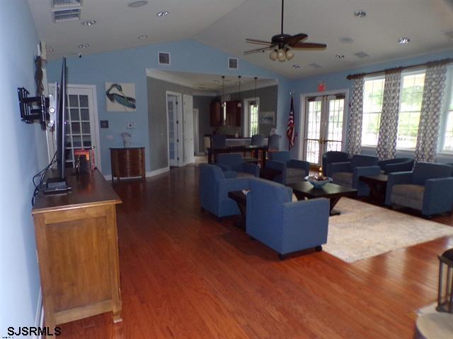 living area with vaulted ceiling, french doors, wood finished floors, and visible vents