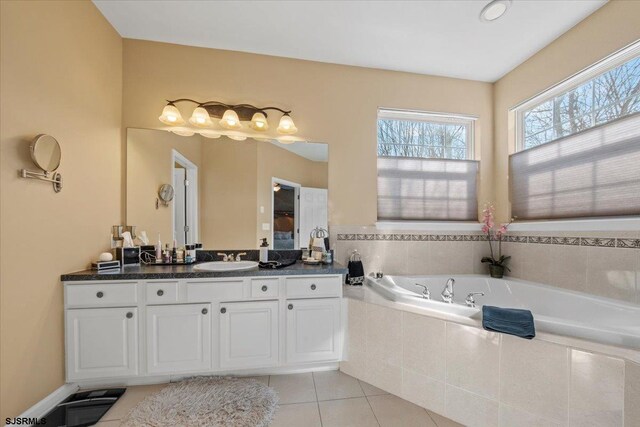 bathroom featuring a garden tub, tile patterned flooring, and vanity