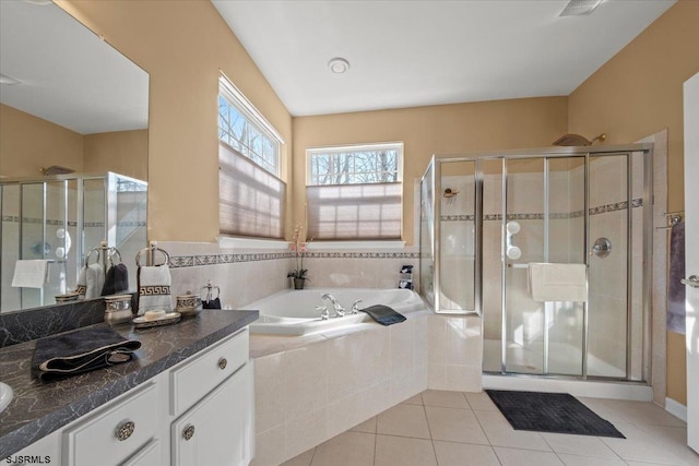 full bath featuring a garden tub, tile patterned floors, a stall shower, and vanity