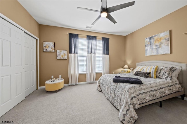 bedroom with a closet, visible vents, carpet flooring, ceiling fan, and baseboards