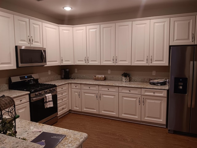 kitchen featuring light stone counters, dark wood-style flooring, stainless steel appliances, recessed lighting, and white cabinetry