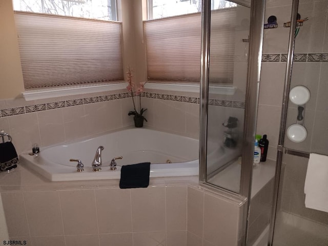 bathroom with a garden tub and a shower stall