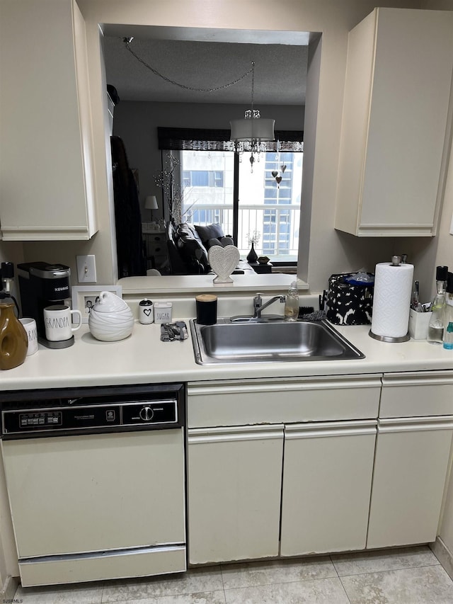 kitchen with white cabinetry, white dishwasher, a chandelier, and sink