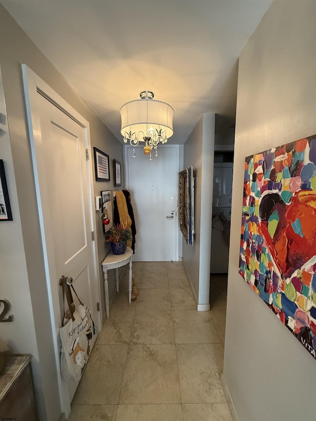 hallway featuring light tile patterned flooring and a chandelier