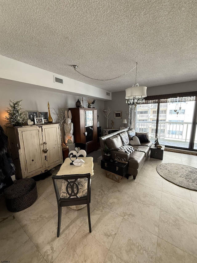 living room featuring a notable chandelier and a textured ceiling