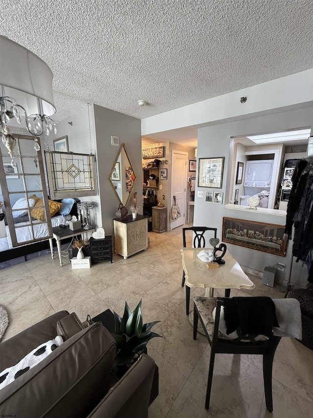 living room featuring a notable chandelier and a textured ceiling