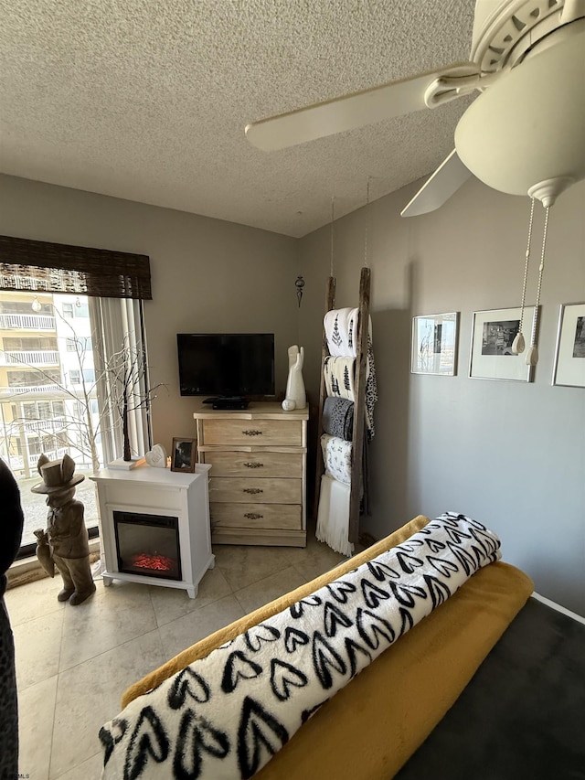 tiled bedroom with ceiling fan and a textured ceiling