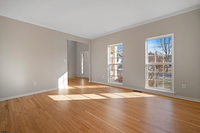 spare room featuring ornamental molding and light wood-type flooring