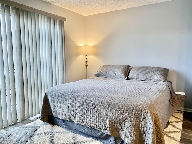 bedroom with hardwood / wood-style floors and a textured ceiling