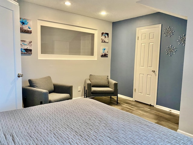 bedroom featuring hardwood / wood-style flooring and a textured ceiling