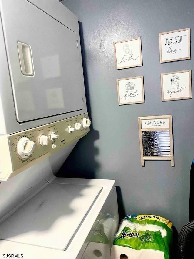 laundry area featuring stacked washer / drying machine