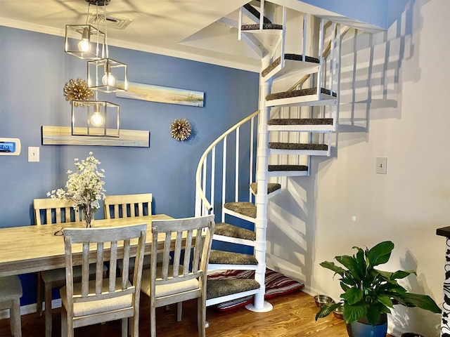 dining room with crown molding and hardwood / wood-style floors