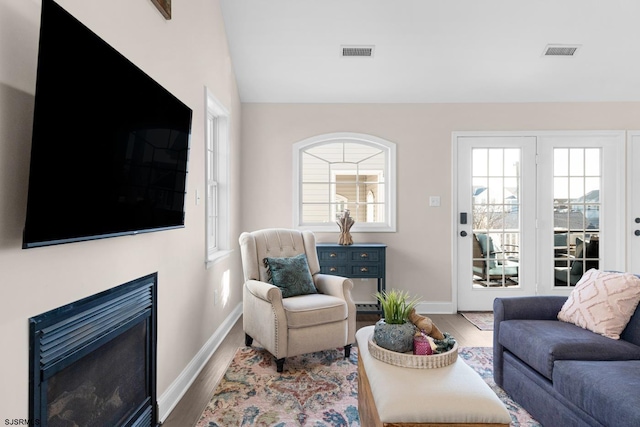 living room featuring wood-type flooring and vaulted ceiling