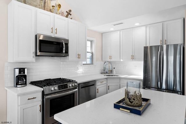 kitchen featuring white cabinetry, appliances with stainless steel finishes, sink, and vaulted ceiling