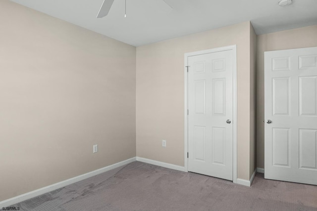 unfurnished bedroom featuring ceiling fan and light carpet