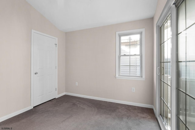 carpeted spare room featuring lofted ceiling