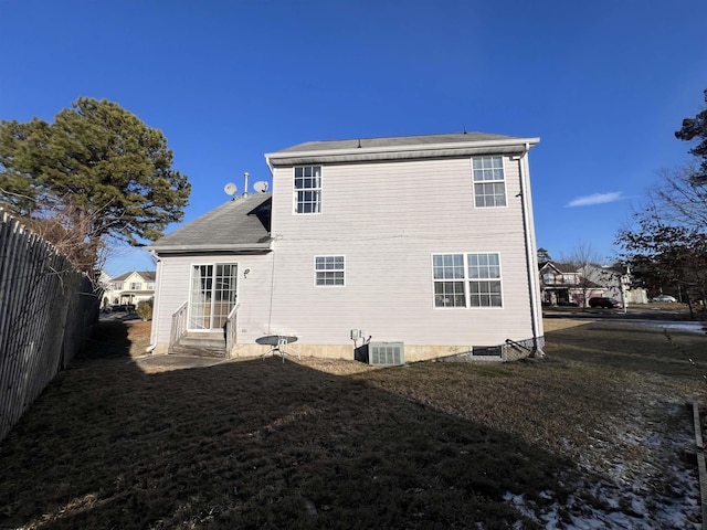 back of property with a yard and central AC