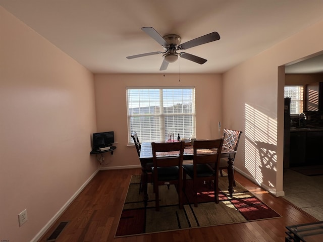 dining space with sink, dark wood-type flooring, and ceiling fan