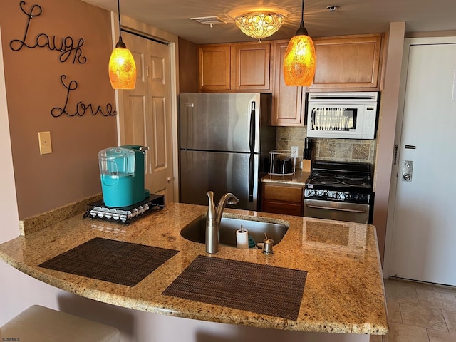 kitchen featuring appliances with stainless steel finishes, pendant lighting, and kitchen peninsula