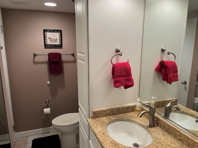 bathroom featuring tile patterned flooring, vanity, and toilet