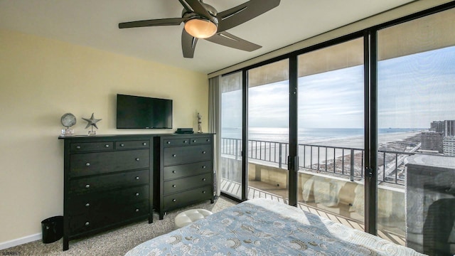 carpeted bedroom with ceiling fan, a wall of windows, and access to exterior