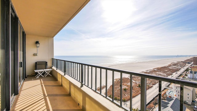 balcony with a water view and a beach view