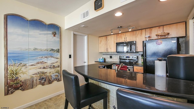 kitchen featuring kitchen peninsula, decorative backsplash, and black appliances