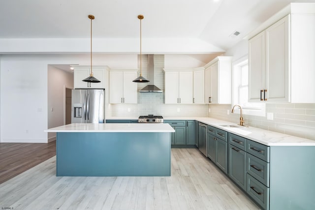 kitchen featuring sink, white cabinetry, decorative light fixtures, a center island, and stainless steel fridge