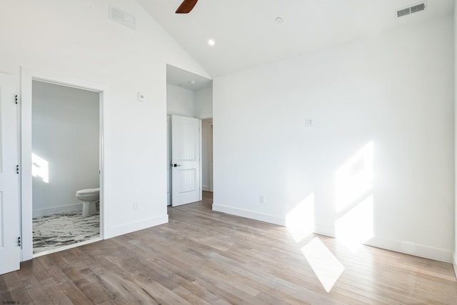 unfurnished bedroom featuring ensuite bathroom, high vaulted ceiling, ceiling fan, and light hardwood / wood-style floors