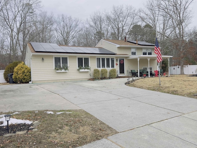 view of front of house featuring a porch and solar panels