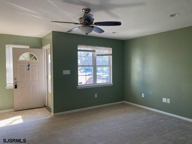 carpeted foyer entrance with ceiling fan