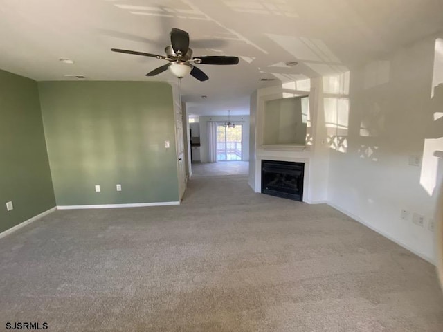 unfurnished living room featuring ceiling fan and carpet flooring