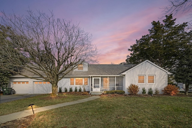 view of front of home featuring a garage, a lawn, and a porch