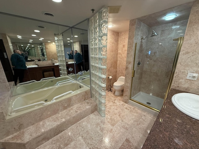 full bathroom featuring independent shower and bath, vanity, tile walls, and toilet